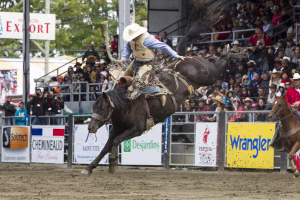 Photographie de rodéo prise lors du Festival Western de St-Tite 2012, montrant l’intensité de la compétition et l’ambiance emblématique du festival.