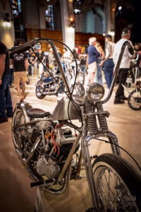 Gros plan sur le moteur chromé et le réservoir personnalisé d'une moto chopper style années 70.