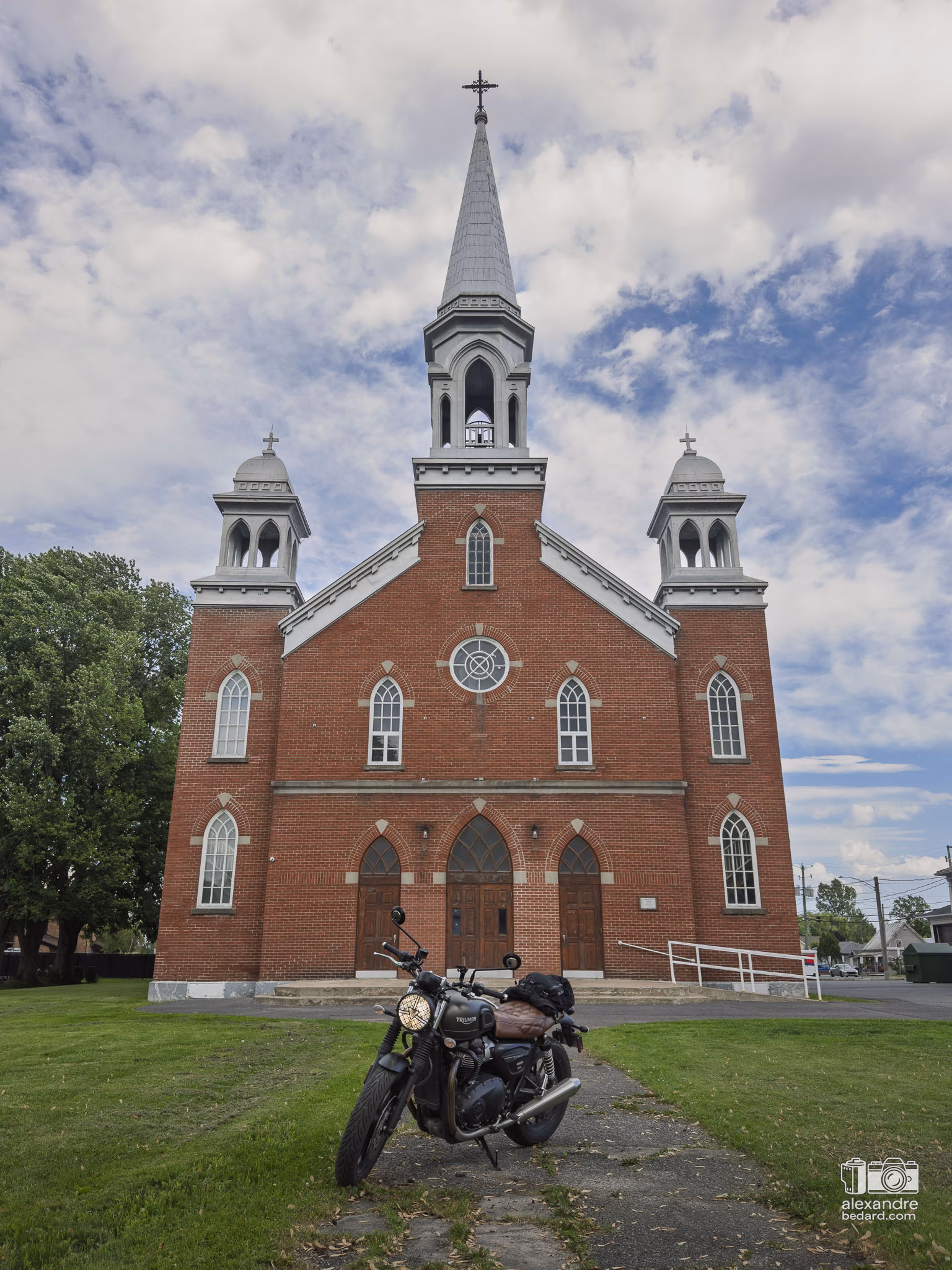 Gros plan sur une moto stationnée pendant une pause devant l'église de Sainte-Victoire-de-Sorel, lors d'un road trip de 250 km en Montérégie.