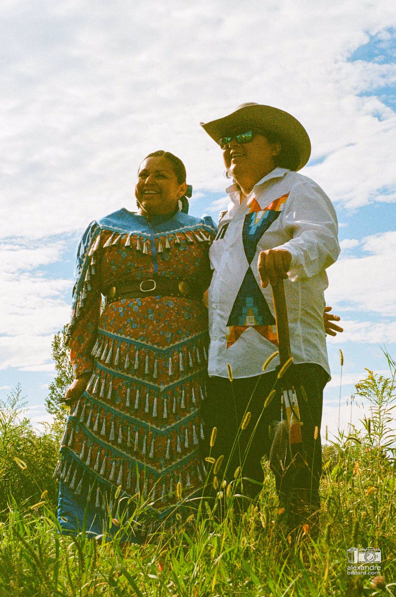 Portrait en photographie argentique d'une femme participante arborant une regalia traditionnelle richement ornée de perles et de rubans