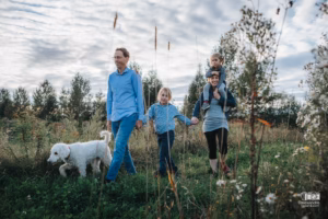 Enfants courant joyeusement dans les herbes hautes lors d'une journée champêtre.