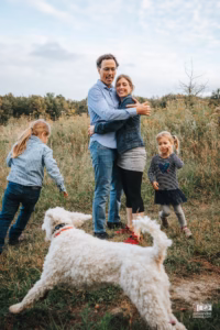 Enfants courant joyeusement dans les herbes hautes lors d'une journée champêtre.