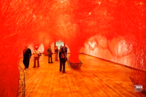 Installation d'art immersif de Chiharu Shiota au MBAM montrant un réseau dense de fils rouges tissés du sol au plafond.