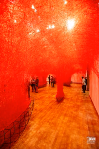 Installation d'art immersif de Chiharu Shiota au MBAM montrant un réseau dense de fils rouges tissés du sol au plafond.
