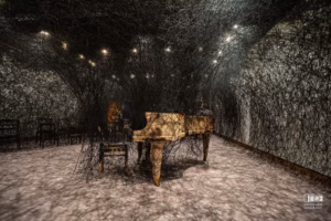 Piano calciné et chaises brûlées enveloppés dans une toile complexe de fils noirs suspendus au Musée des beaux-arts de Montréal.