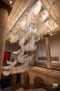 Structures de barques suspendues au milieu d'une immense toile arachnéenne de fils au MBAM.